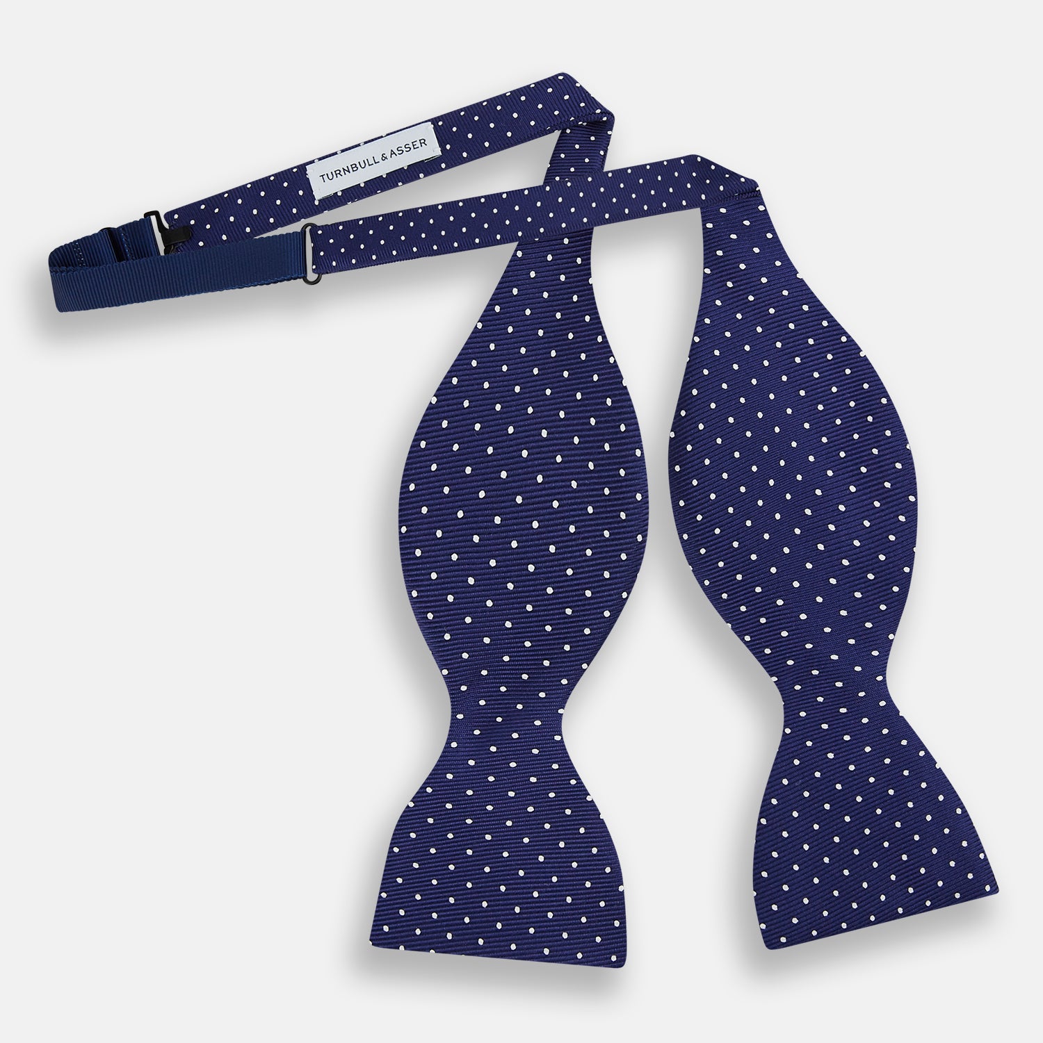 View 2 of product The Turnbull & Asser Azzurro and White Spot Silk Bow Tie features a classic blue silk design with small white spots, shown elegantly against a plain white background.