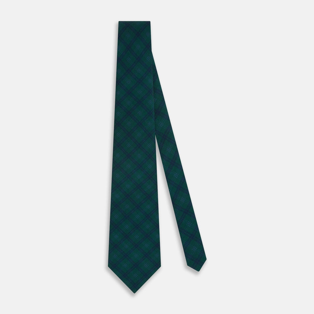 The Turnbull & Asser Forest Melange Tartan Plaid Silk Tie features a classic green and blue plaid design, rolled up and displayed on a plain light background—reflecting timeless Scottish heritage.