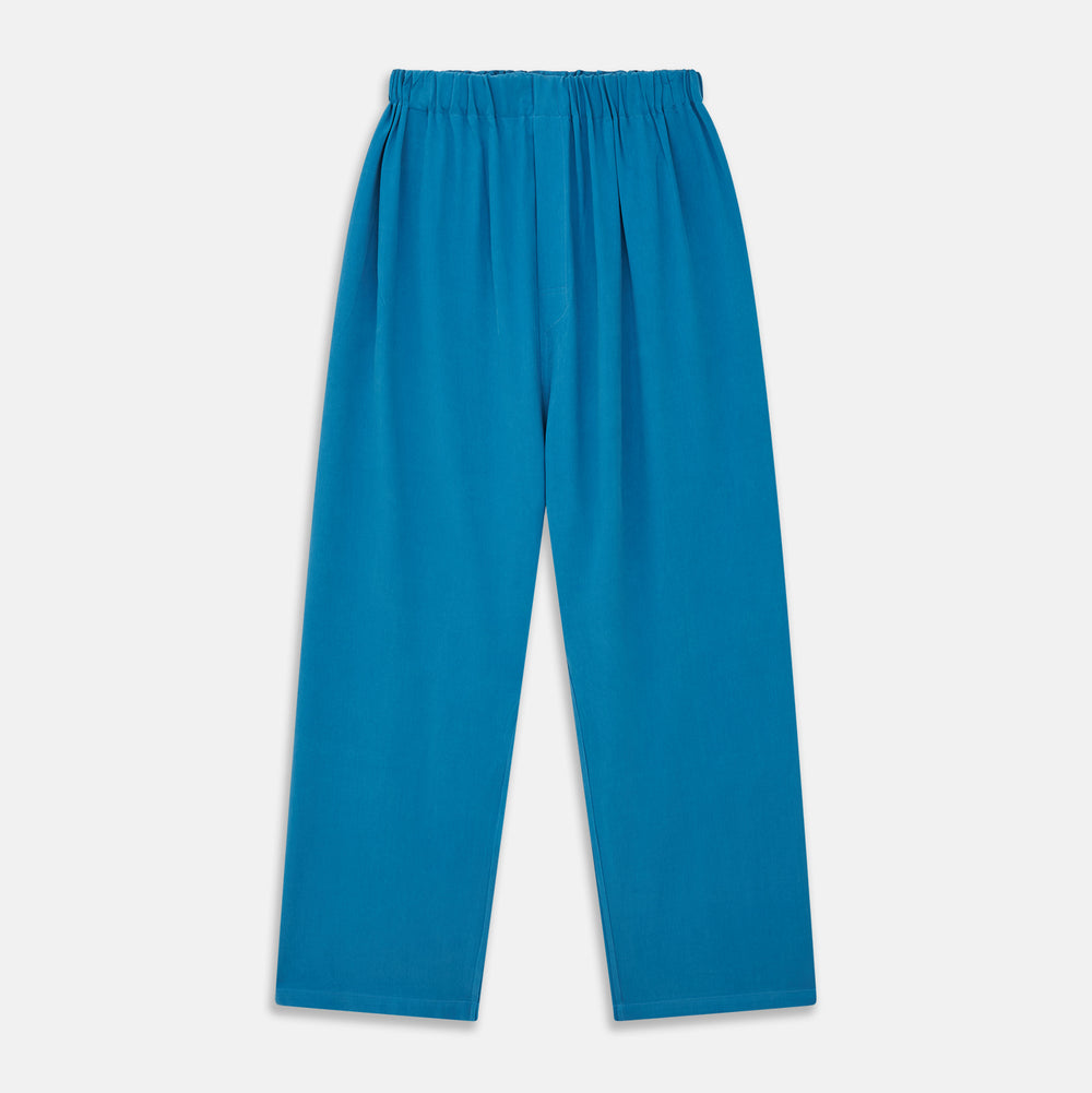 The Turnbull & Asser Blue Silk Hyde Pyjama Set features a modern fit with a long-sleeve button-up top, three pockets, white trim, and elastic-waist pants, all shown on a white background.