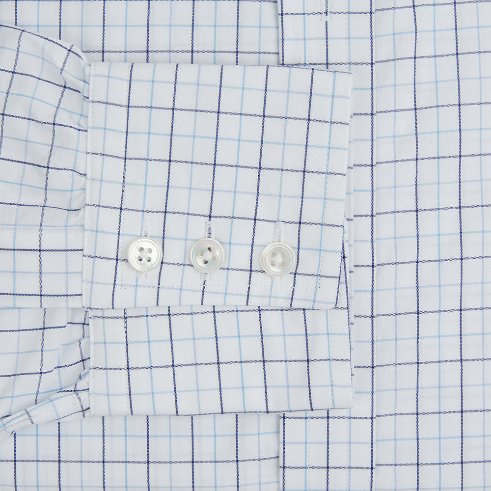 The Blue Overlay Grid Check Mayfair Shirt by Turnbull & Asser features a light blue and white grid check pattern with long sleeves and button-up design, making it a versatile wardrobe staple. Displayed on a plain white background.