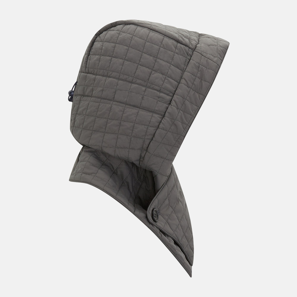 The Turnbull & Asser Shadow Grey Quilted Hood with Neck Warmer features a button closure, inspired by quilted jacket hoods, and is displayed on a plain white background.