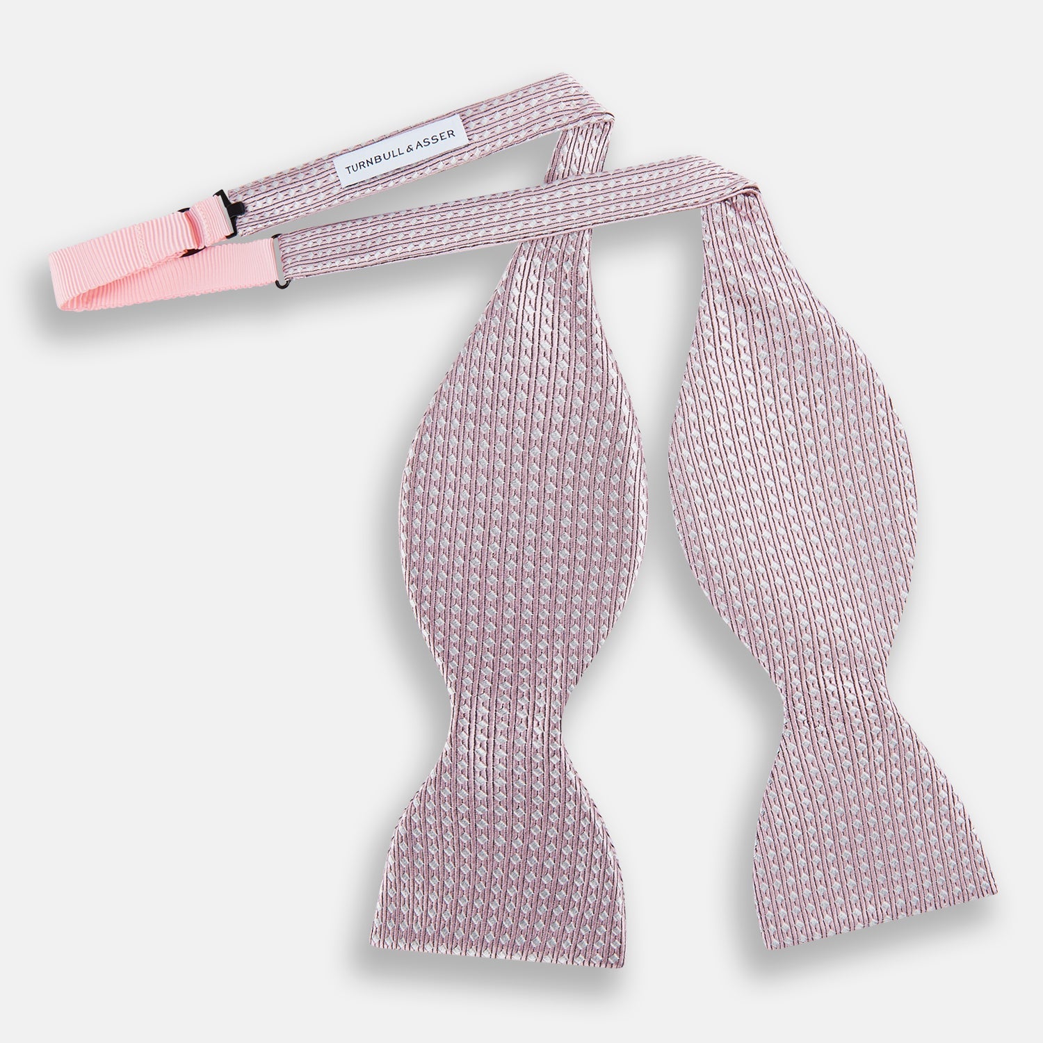 View 2 of product The Turnbull & Asser Pale Pink and White Square Silk Bow Tie features white stripes and subtle square patterns, ideal for formalwear. Shown on a white background.