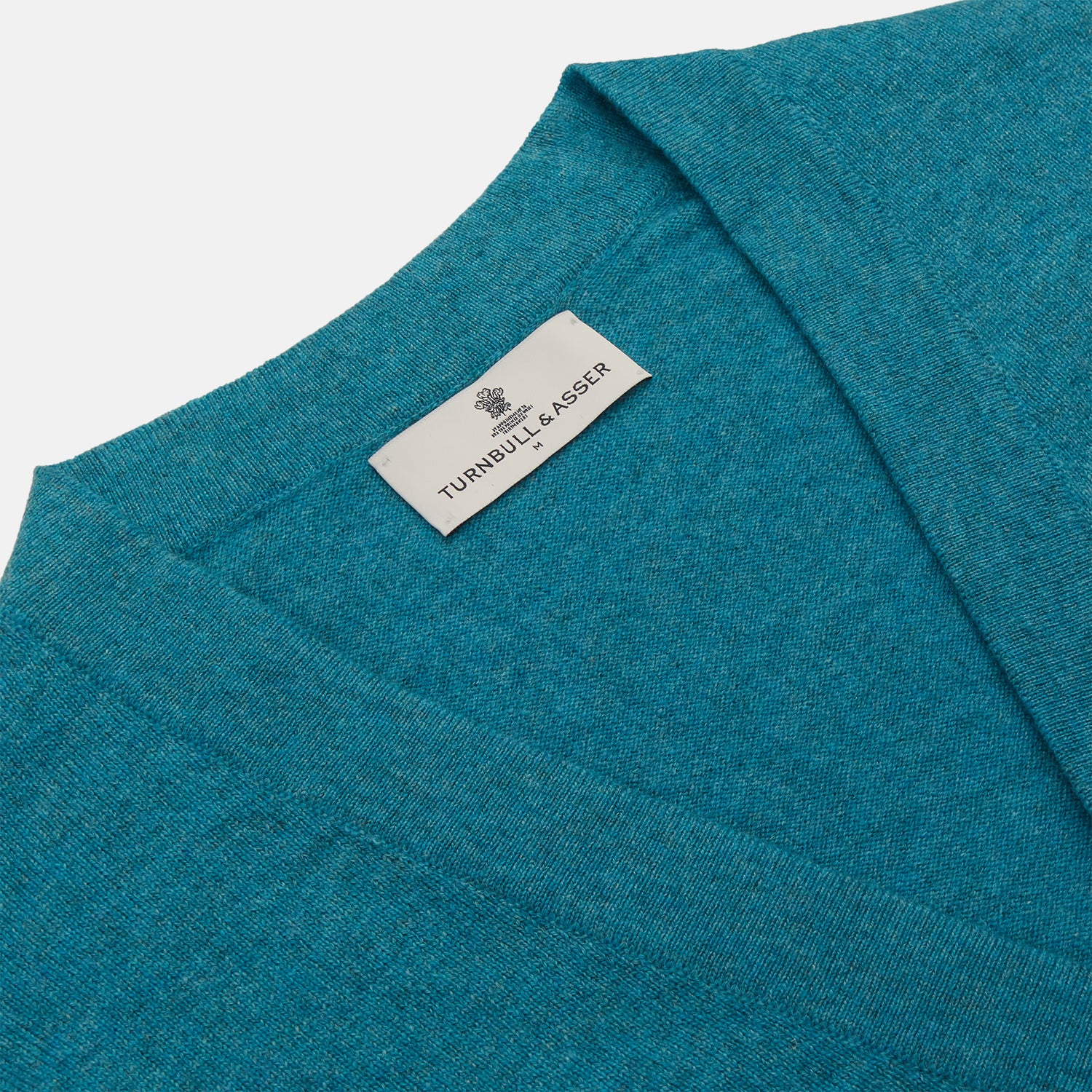 View 2 of product The Teal Lachlan Cashmere Cardigan by Turnbull & Asser features long sleeves, front pockets, and ribbed hem and cuffs. Displayed flat on a white background, this cozy piece is inspired by classic Scottish knitwear.