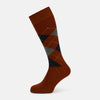 View 1 of product The Turnbull & Asser Rust Wool Check Mid-Length Sock features a brown wool design with black, gray, and orange checks, shown on a white background.