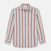 View 2 of product A close-up of Turnbull & Asser’s Red, Blue & White Stripe Cotton Fabric is displayed within a circular frame on a light gray background, showcasing its diagonal white, navy blue, red, and beige stripes.