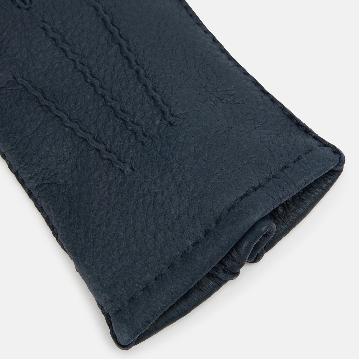 View 2 of product A pair of Turnbull & Asser Navy Cashmere-Lined Peccary Leather Gloves, one showing the palm with a buttoned strap and the other the back with decorative stitching, elegantly displayed on a white background.