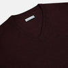 View 2 of product The Turnbull & Asser Burgundy Fine Merino V-Neck Jumper features a classic plain knit design with long sleeves, showcased against a crisp white background.