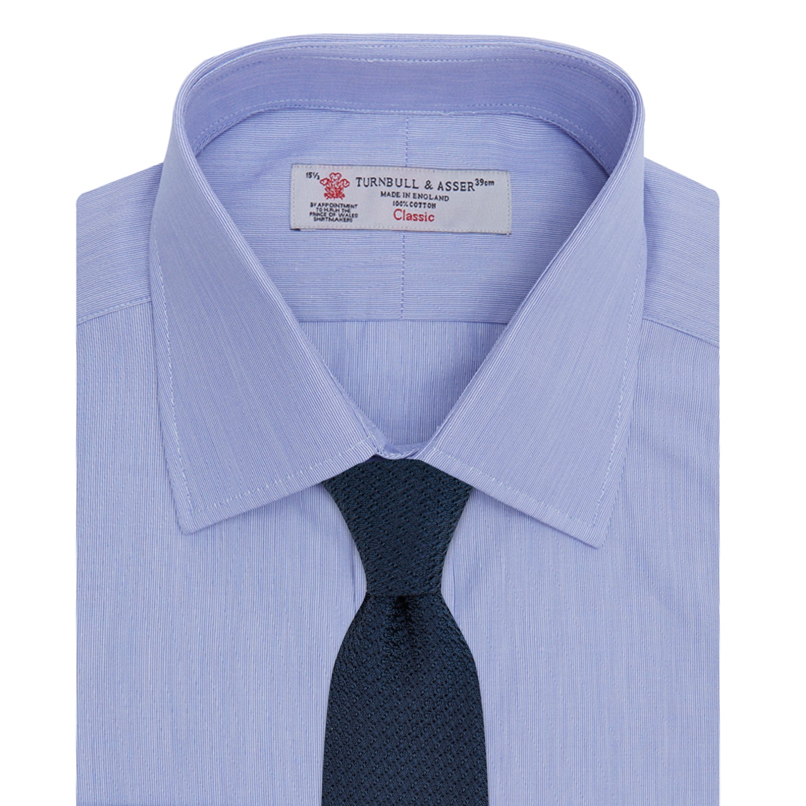 View 4 of product The Turnbull & Asser Blue Hairline Stripe Shirt features a T&A collar, 3-button cuffs, and white buttons. Made from light blue cotton with subtle stripes, it’s neatly folded with the label visible inside the collar on a plain white background.