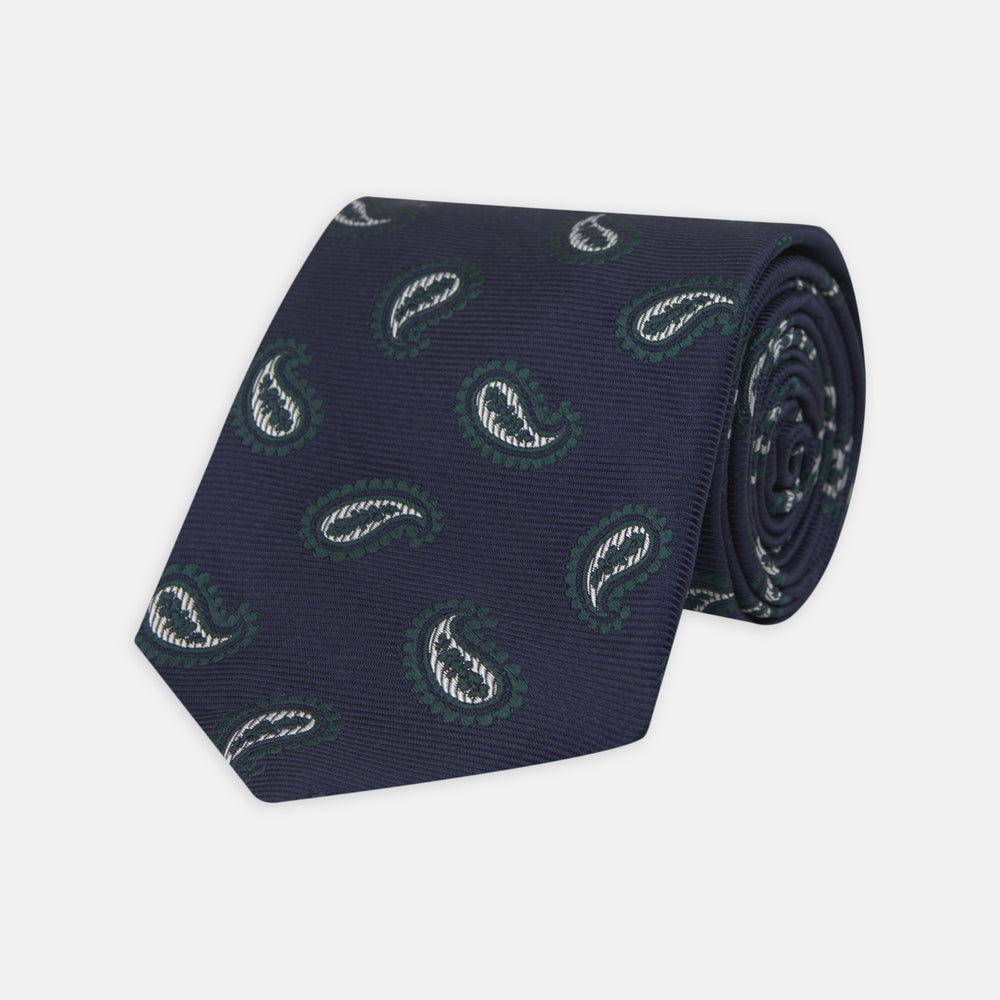 The Turnbull & Asser Navy and Forest Green Floating Paisley Silk Tie features a green and white paisley pattern, elegantly rolled up for a stylish presentation.