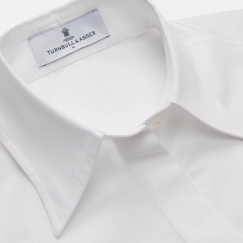 The White Cotton Tailored Bianca Shirt by Turnbull & Asser features a pointed collar and button cuffs, crafted from soft organic cotton and displayed flat on a white background for timeless elegance.