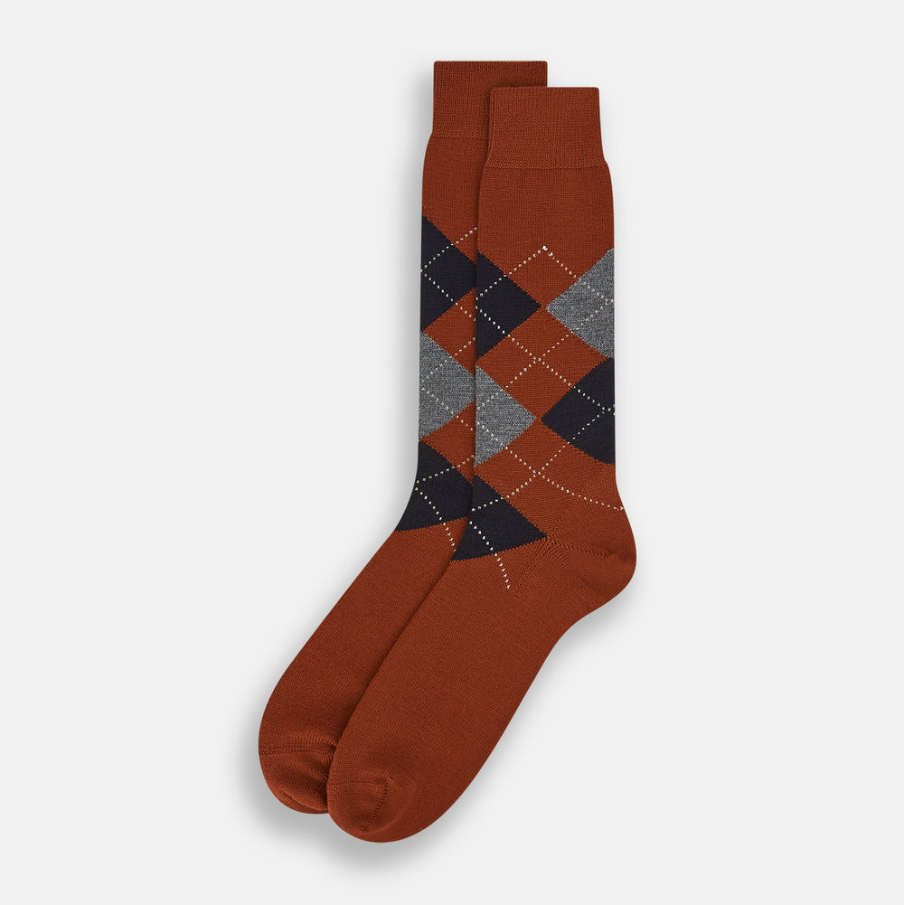 The Turnbull & Asser Rust Wool Check Mid-Length Sock features a brown wool design with black, gray, and orange checks, shown on a white background.