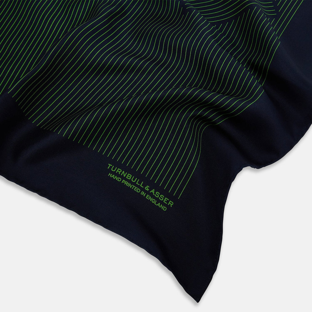 The Navy and Fern Green Stripe Silk Pocket Square by Turnbull & Asser features green vertical and diagonal stripes, hand-rolled edges, and "TURNBULL & ASSER HAND PRINTED IN ENGLAND" printed in one corner.