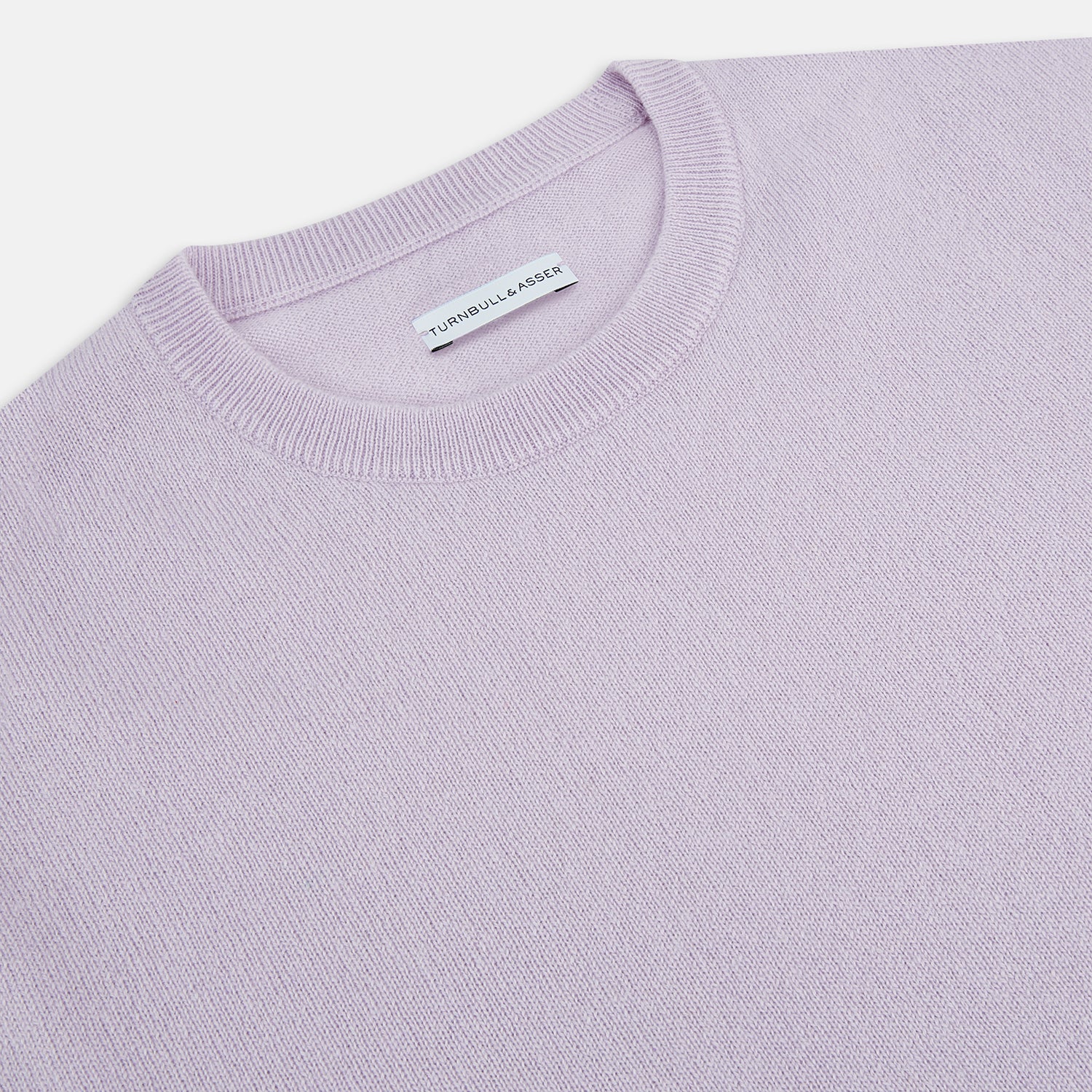 View 9 of product The Turnbull & Asser Lilac Cashmere Round Neck Jumper for men features long sleeves with ribbed cuffs and hem, offering a stylish, refined look. Shown against a white background.