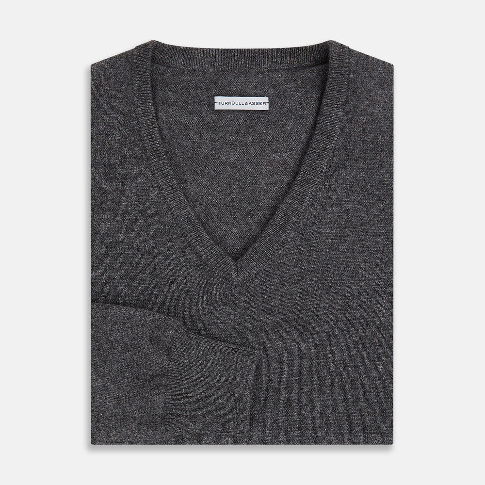 The Charcoal Grey Cashmere V-neck Jumper by Turnbull & Asser features ribbed cuffs, hem, and neckline—an essential knitwear piece, shown on a white background.
