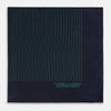 View 3 of product The Turnbull & Asser Navy and Hunter Green Stripe Silk Pocket Square features thin green stripes, hand-rolled edges, and "TURNBULL & ASSER HAND PRINTED IN ENGLAND" in green on the bottom right corner.