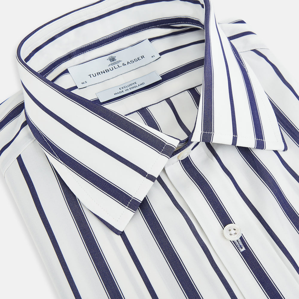 The Navy Double Stripe Mayfair Shirt by Turnbull & Asser features classic long sleeves, buttoned cuffs, a collar, and a slightly curved hem with timeless vertical navy and white stripes.