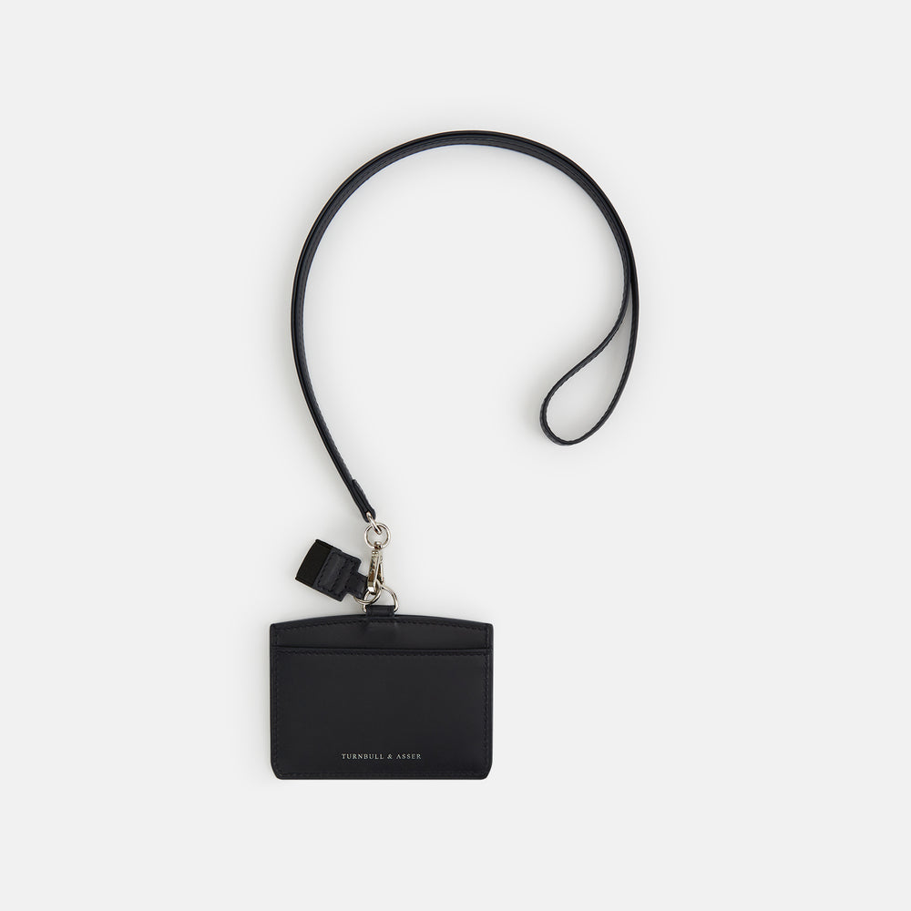 The Turnbull & Asser Navy ID Card Holder is shown with a matching lanyard strap and key cover, all featuring silver hardware, against a plain white background.