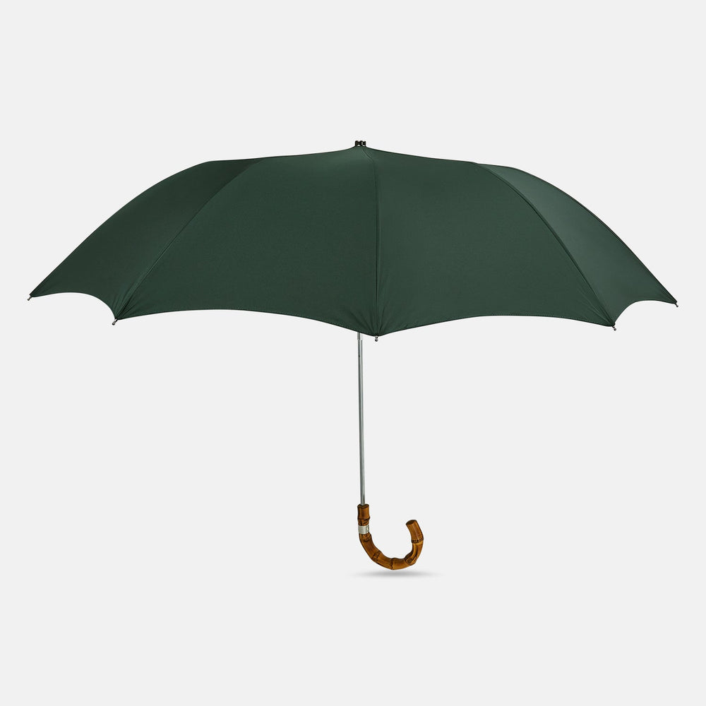 The Turnbull & Asser Forest Green Telescopic Umbrella with a whangee crook handle is opened and displayed on a plain white background, highlighting its expert craftsmanship and timeless style.