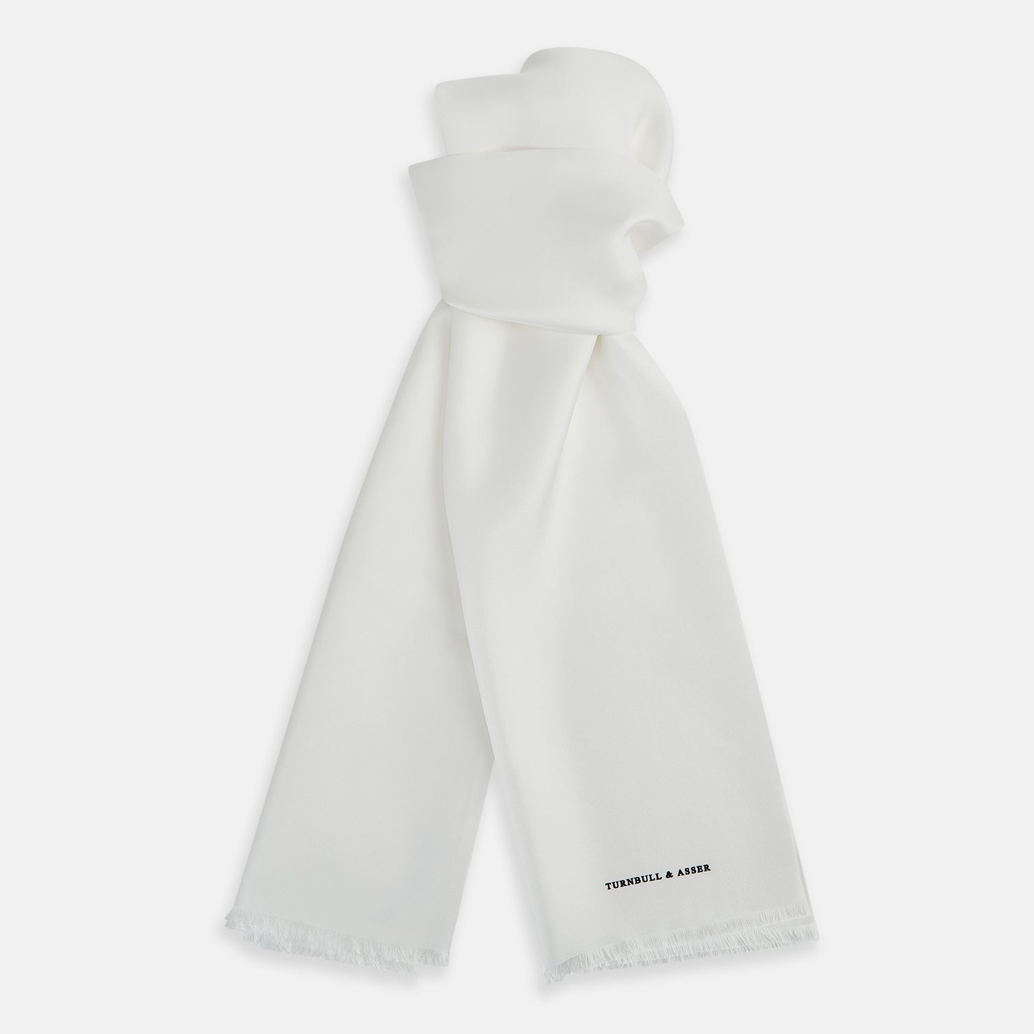 Image 1 of product The Turnbull & Asser White Silk Scarf features fringed edges and discreet black branding in the corner, making it a refined accessory for tuxedo jackets or formal wear. Presented neatly folded on a plain white background.