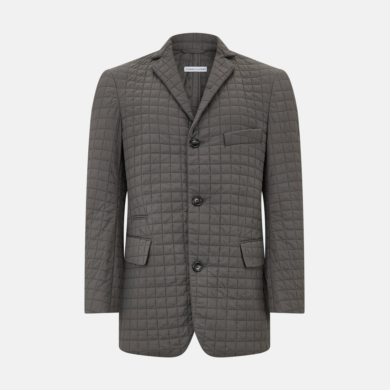 Image 1 of product The Fulham Shadow Grey Single-Breasted Quilted Blazer by Turnbull & Asser features a checkered pattern, notched lapel, three front buttons, chest pocket, and two flap pockets—ideal for formal wear on a plain white background.