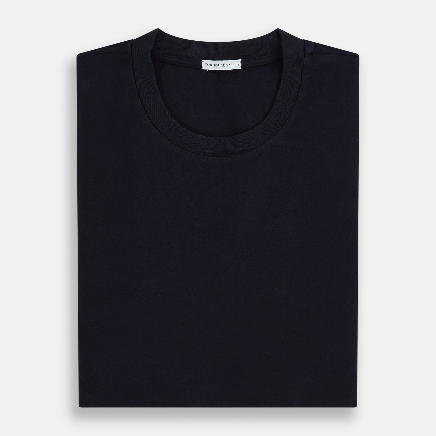 Image 5 of product A navy short-sleeve pyjama shirt by Turnbull & Asser is laid flat on a white background, displaying the front view. Its soft fabric ensures comfort with no visible logos, designs, or patterns on the shirt.