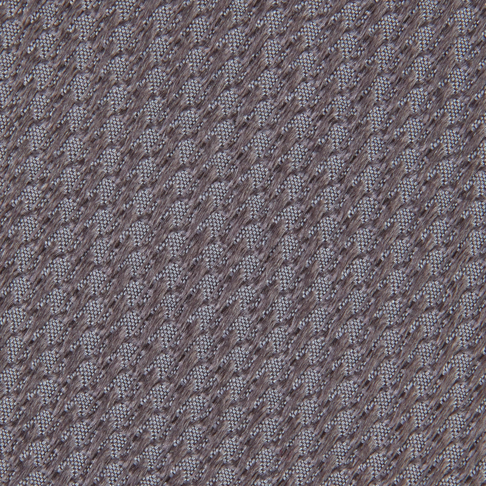 A close-up of the Dark Grey Plain Woven Lace Silk Tie by Turnbull & Asser, neatly rolled and textured, displayed on a light background—an elegant accessory for smart wardrobes.