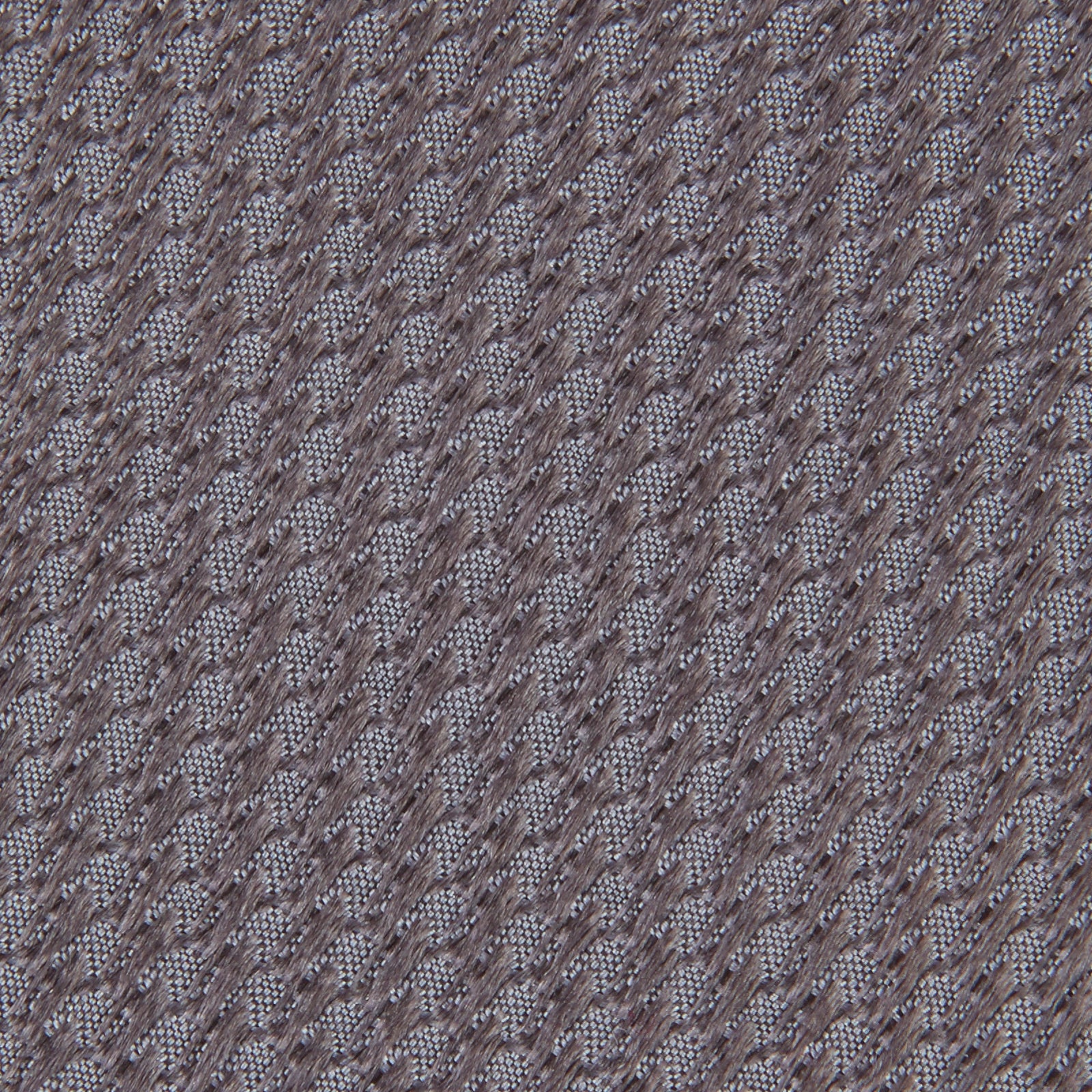 View 3 of product A close-up of the Dark Grey Plain Woven Lace Silk Tie by Turnbull & Asser, neatly rolled and textured, displayed on a light background—an elegant accessory for smart wardrobes.