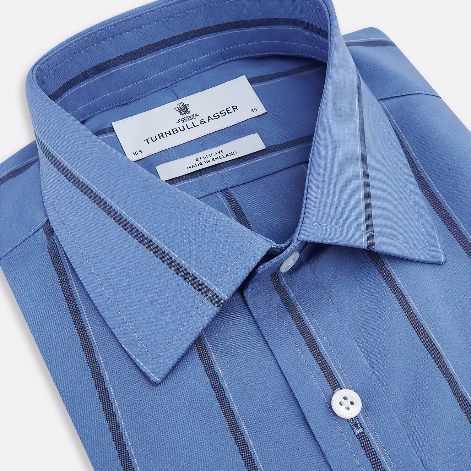 View 2 of product The Turnbull & Asser Colony Blue Track Stripe Mayfair Shirt is crafted from Italian cotton with long sleeves, dark blue track stripes, a classic collar, and buttoned cuffs, shown against a white background.