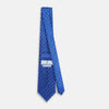 View 4 of product The Turnbull & Asser Blue and White Micro Dot Silk Tie features a subtle herringbone pattern with small white dots, ideal for modern office attire, and is shown rolled up on a white background.