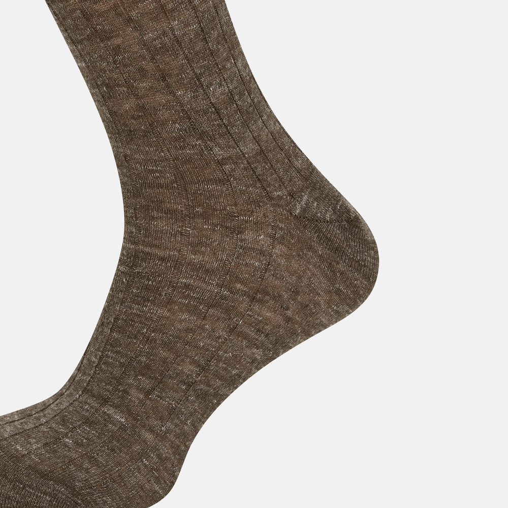 A single Dark Chocolate Linen Mid-Length Sock by Turnbull & Asser, ribbed and breathable, stands upright with its foot slightly raised against a plain white background.