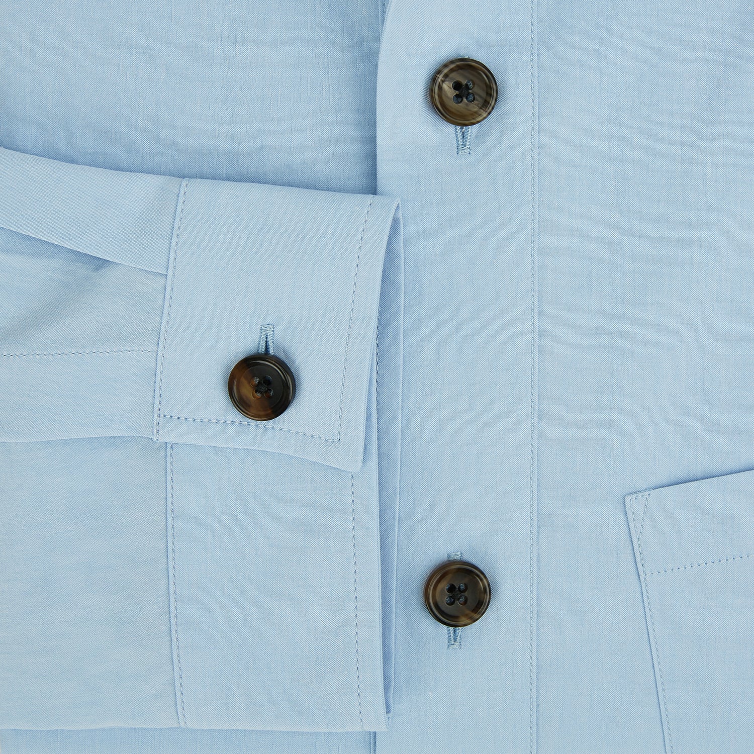 View 4 of product The Blue Hyde Overshirt by Turnbull & Asser features a light blue hue, long sleeves, a button-up front, and a single chest pocket. Crafted from sanforised cotton and shown laid flat on a white background.