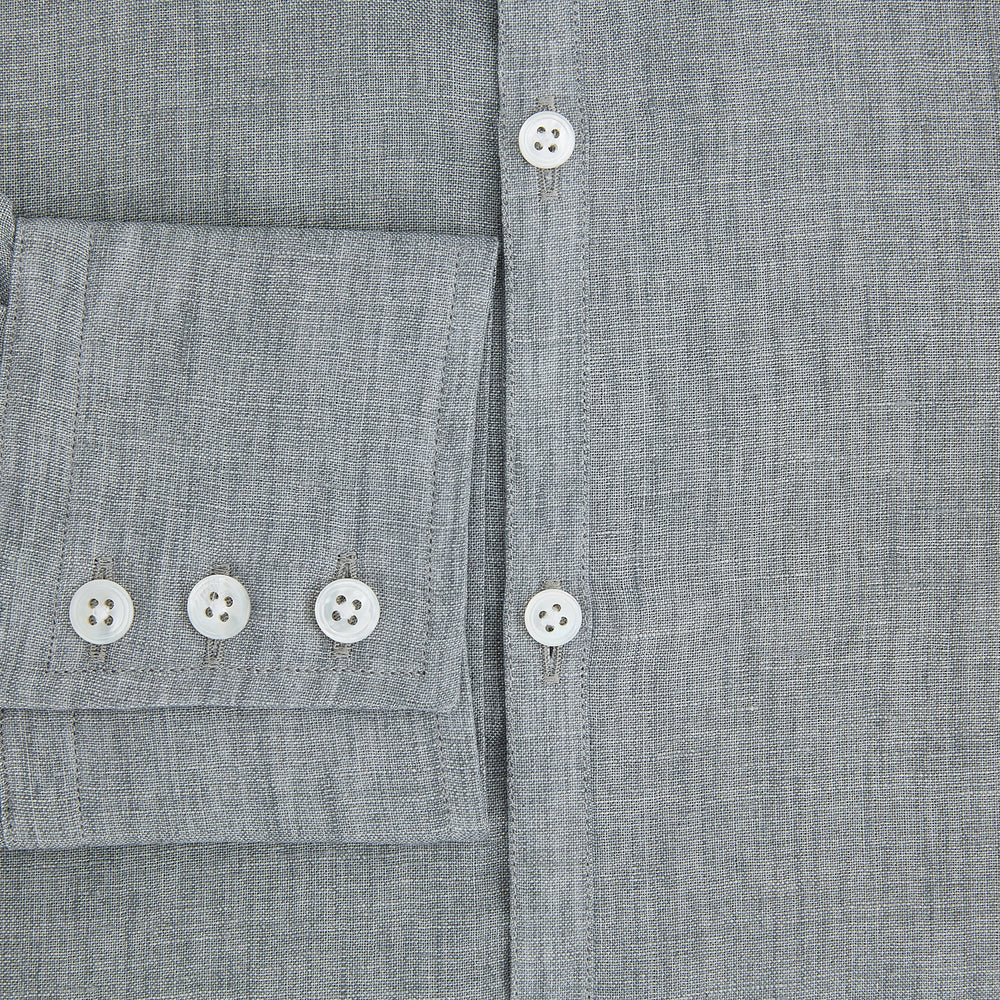The Grey Linen Westminster Shirt by Turnbull & Asser is a long-sleeve, light gray button-up with a formal collar and white buttons, highlighting British craftsmanship and laid flat on a white background.