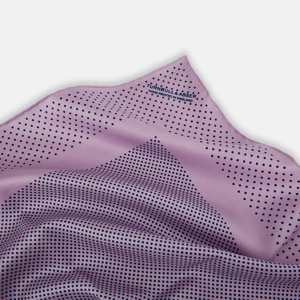 The Lilac Dot Silk Pocket Square by Turnbull & Asser is handmade from silk in a folded design, featuring small black polka dots and a solid border.