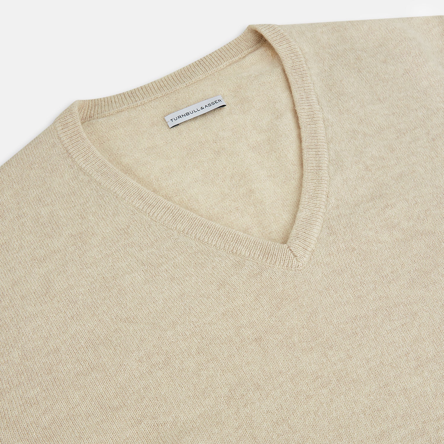 View 2 of product The Turnbull & Asser Ivory Cashmere V-Neck Jumper, with long sleeves and ribbed cuffs and hem, is shown against a plain white background.