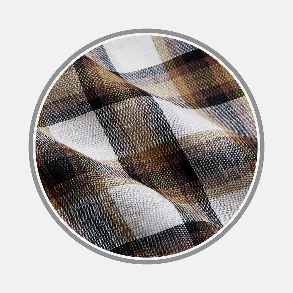 Close-up of Turnbull & Asser’s Brown Multi Check Linen Fabric, featuring a pattern of black, brown, and white intersecting lines within a circular frame on a light gray background. The linen surface is slightly wrinkled.