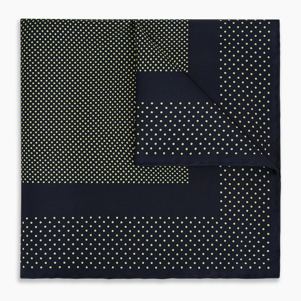 The Turnbull & Asser Navy and Gold Silk Pocket Square is handmade, featuring small gold polka dots on navy with a solid border, displayed neatly folded with one corner turned up.