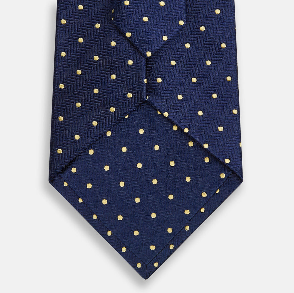 The Turnbull & Asser Navy and Gold Micro Dot Silk Tie showcases subtle herringbone texture with gold micro dots, offering a refined and modern look for the office.