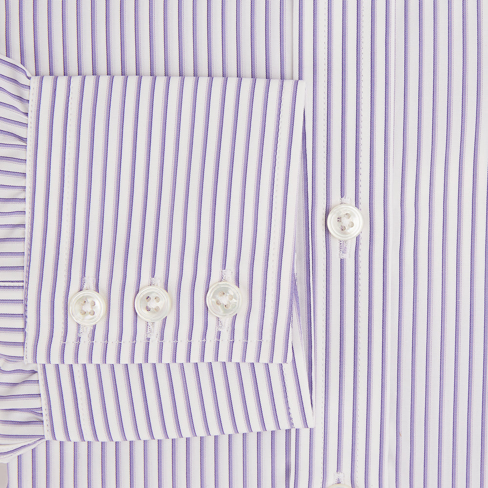 The Turnbull & Asser Purple Shadow Stripe Mayfair Shirt features a long-sleeve button-up design with thin vertical blue and white stripes, a T&A collar, and buttoned cuffs, shown on a plain white background.