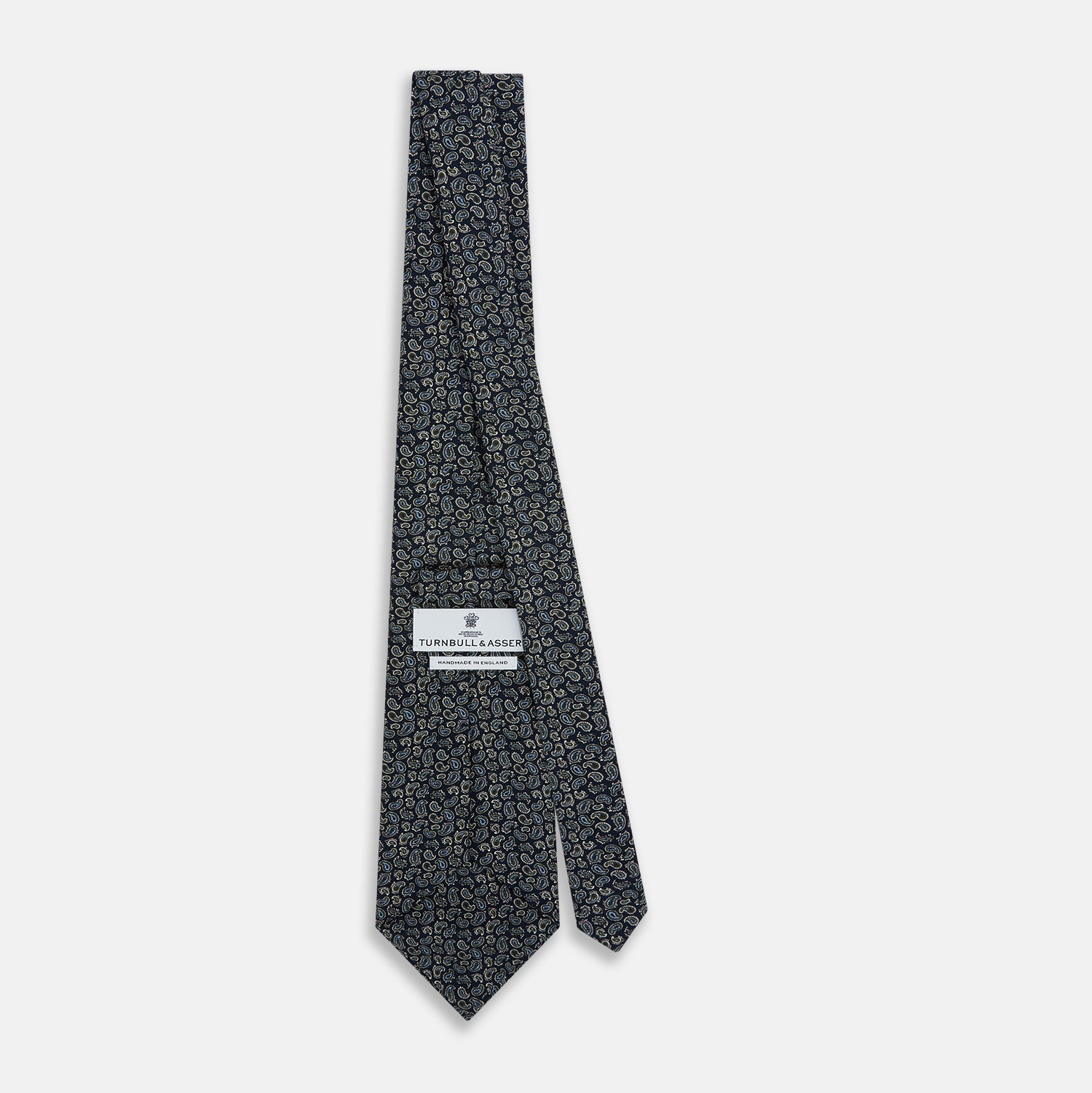 View 4 of product The Turnbull & Asser Navy Paisley Foulard Silk Tie features a refined paisley pattern in blue, white, and beige tones, elegantly rolled and presented against a white background.