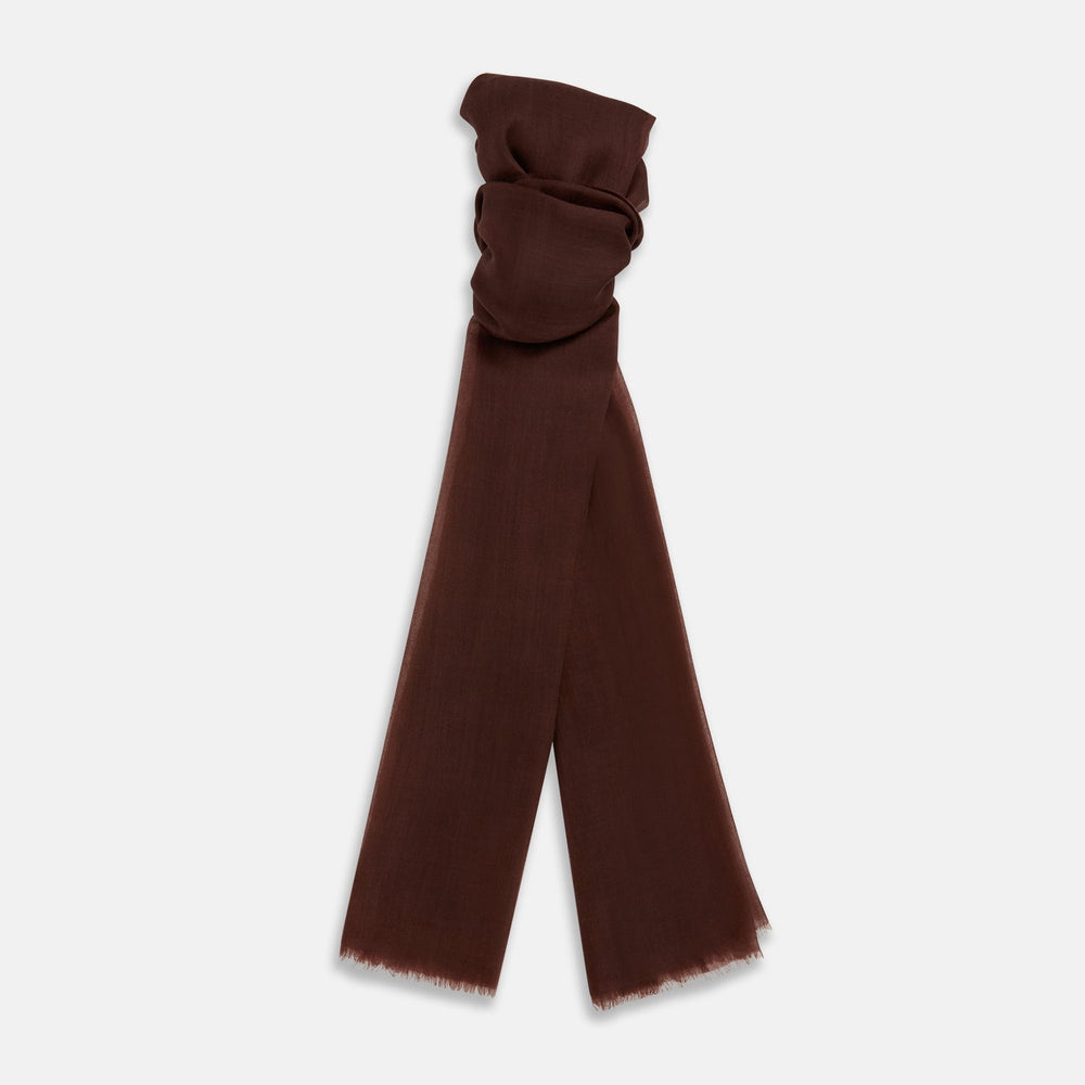 The Turnbull & Asser Dark Chocolate Cashmere Scarf is neatly folded with fringed edges and loose ends, showcasing its lightweight, luxurious fabric on a plain white background.