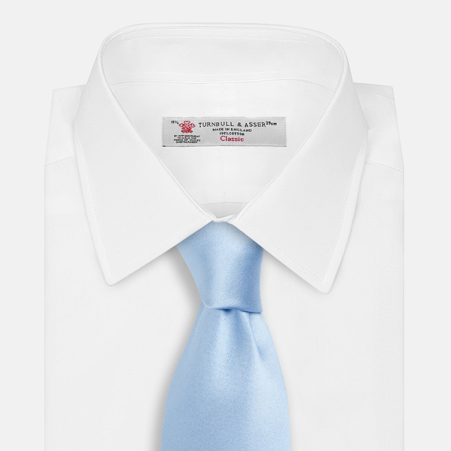 View 2 of product The Turnbull & Asser SATIN RIVER TIE, a neatly rolled light blue silk accessory with a smooth matte finish, is displayed against a plain white background.