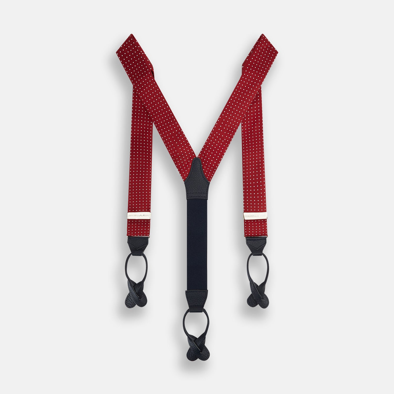 View 1 of product Turnbull & Asser’s Burgundy and White Small Spot Adjustable Silk and Navy Leather Braces feature white polka dots, navy leather loops, and M-shaped elastic straps—a refined statement for standout style.