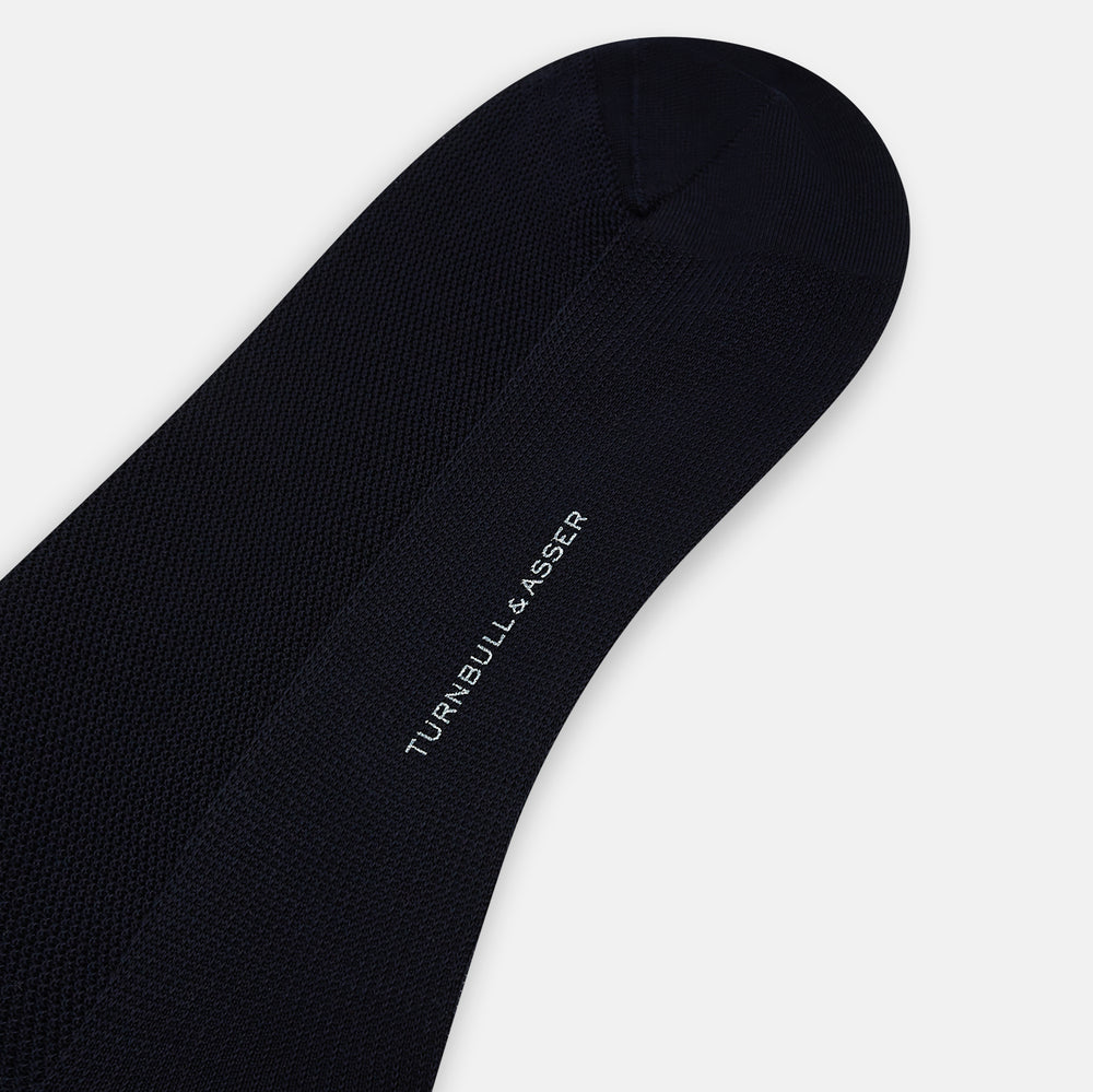 A single Turnbull & Asser Navy Micro Knit Long Sock is shown in a side profile against a plain white background, with the toe pointing downward and the cuff at the top.