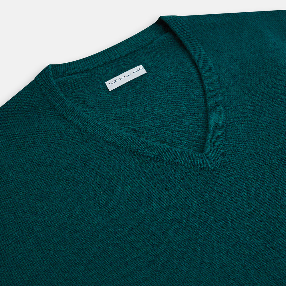 The Moss Green Cashmere V-Neck Jumper by Turnbull & Asser features long sleeves with ribbed cuffs and hem, shown on a plain white background.