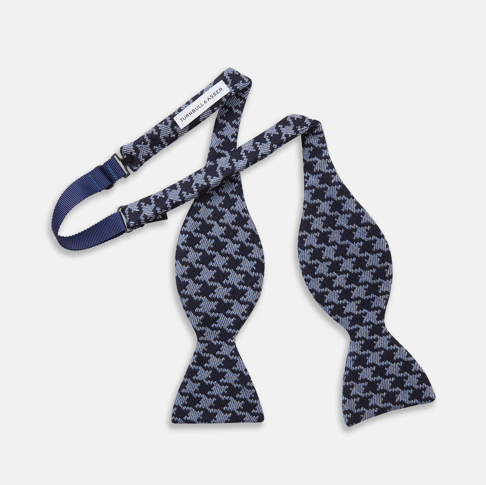 The Turnbull & Asser Navy and Blue Houndstooth Wool Blend Bow Tie features a self-tying design with a blue and black houndstooth pattern, showcased on a plain white background.