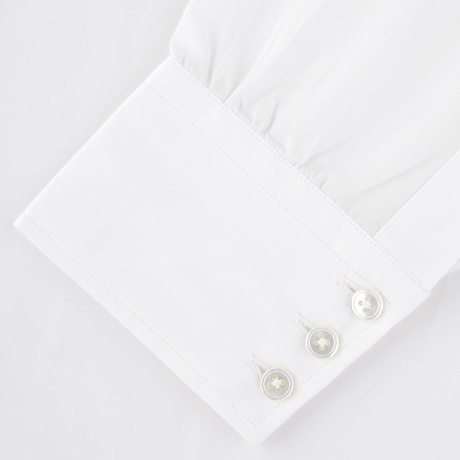 View 2 of product The Turnbull & Asser Two-Fold 120 White Shirt with a Regent collar and 3-button cuffs is neatly folded and displayed against a light blue background.
