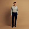 View 1 of product A man stands against a beige background wearing the Turnbull & Asser Cloud Blue Cashmerello Holiday Fit Fellows Shirt, styled with dark trousers, a black belt, and black shoes, looking directly at the camera with a neutral expression.