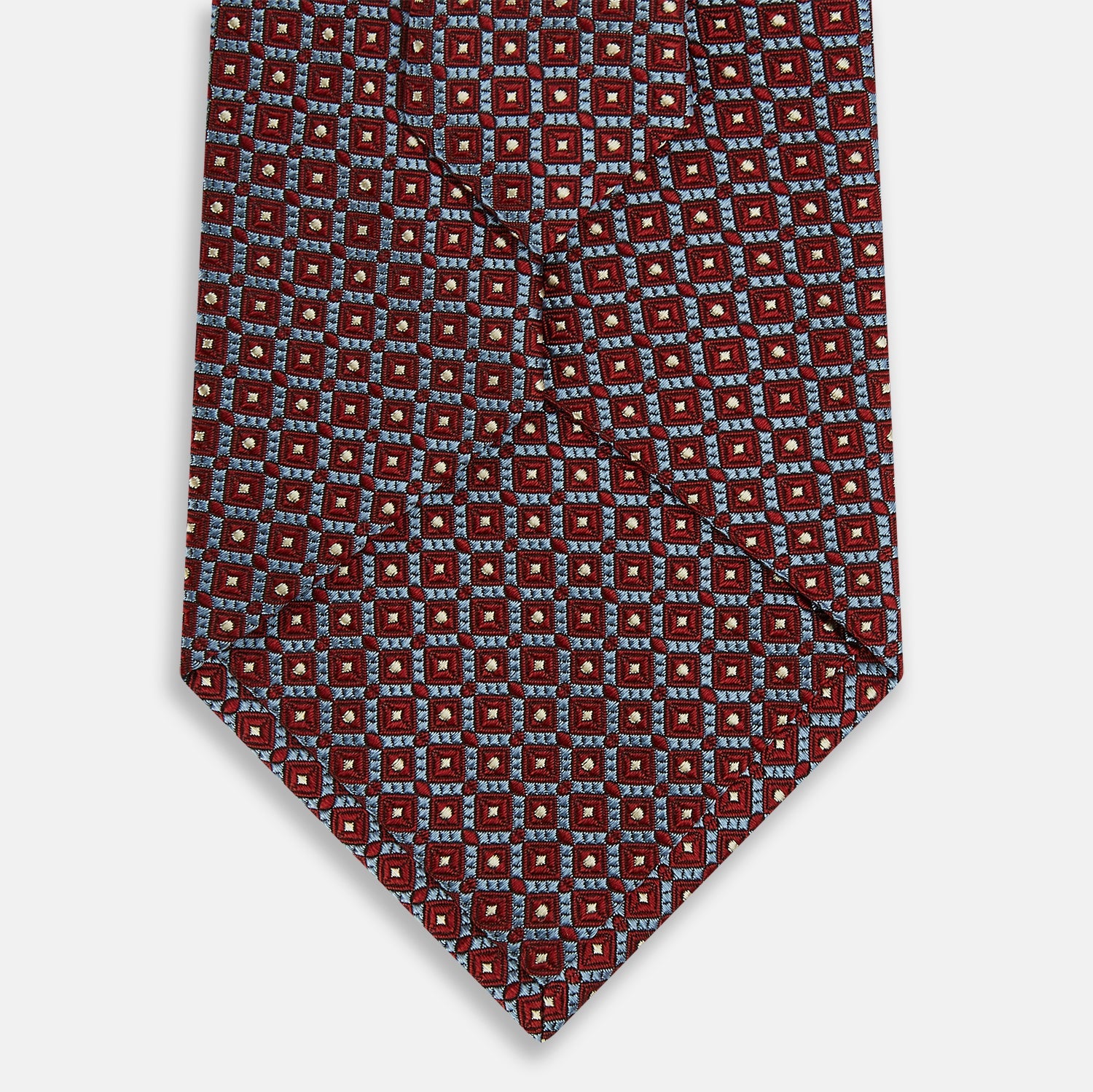 View 3 of product The Turnbull & Asser Burgundy Diamond Silk Tie features a red silk background with a repeating geometric diamond pattern of blue and white squares, exemplifying British craftsmanship.