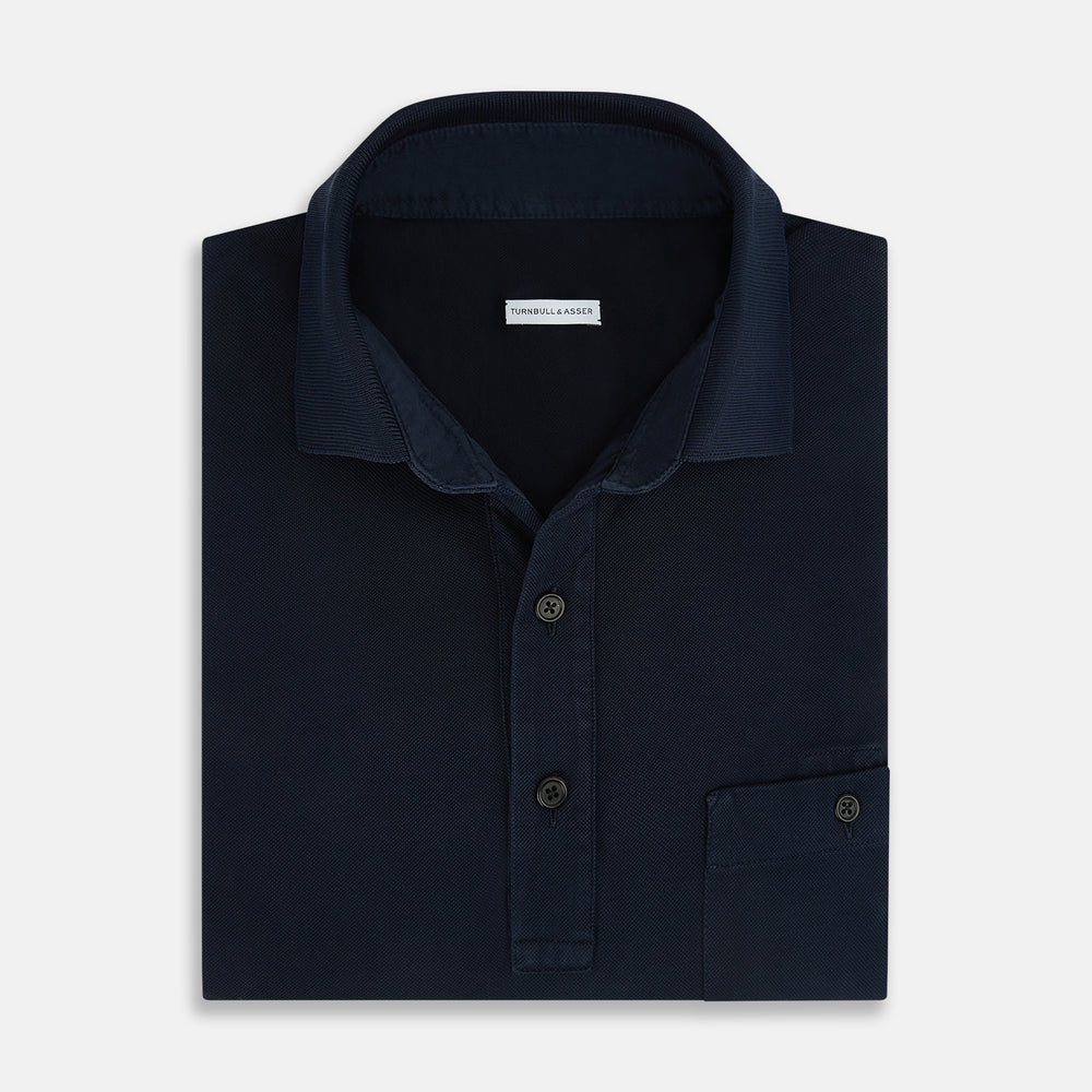 The Turnbull & Asser Navy Polo Shirt features short sleeves, a collar, three-button placket, and a single buttoned chest pocket, shown flat on a plain white background.