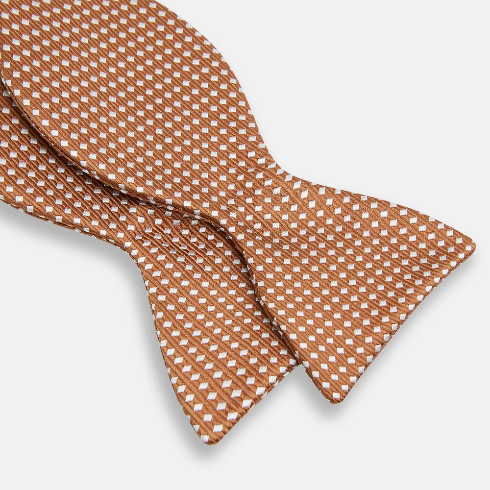 The Turnbull & Asser Brown and White Diamond Silk Bow Tie features a diamond pattern, ideal for formal occasions, showcased on a white background.